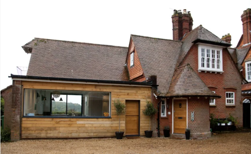 A red brick house with a wood cladded wall